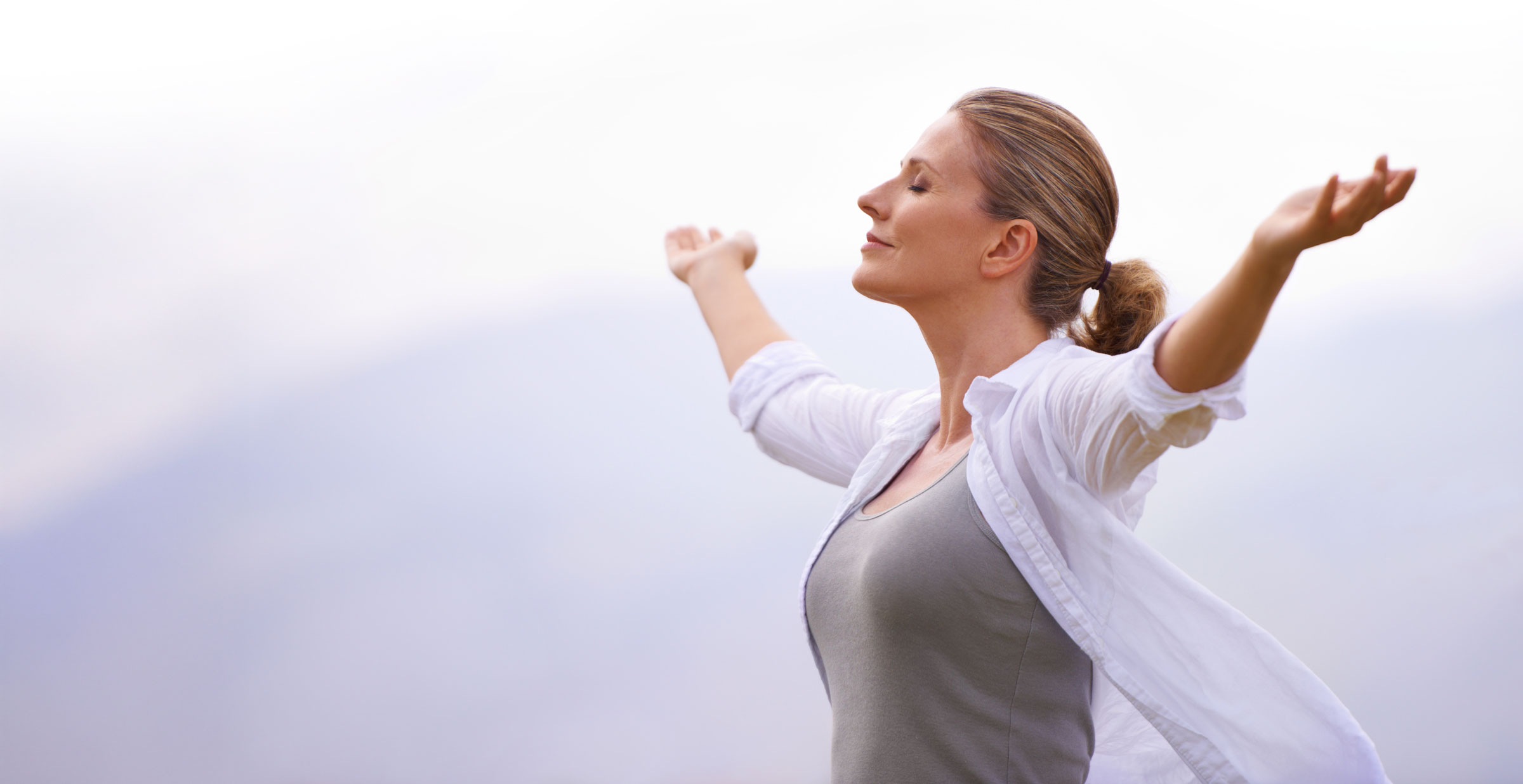 Donna con braccia aperte verso il cielo